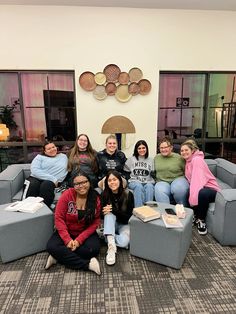 a group of women sitting on top of couches in a living room next to each other