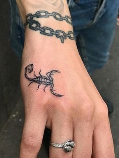 a hand with a scorpion tattoo on it