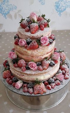 a three tiered cake covered in frosting and strawberries