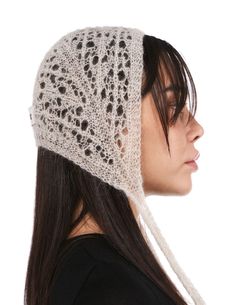 a woman wearing a white knitted hat with lace on it's brim