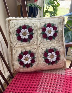 a crocheted pillow sitting on top of a wooden chair