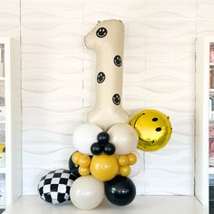 balloons are stacked on top of each other in front of a number one balloon sculpture