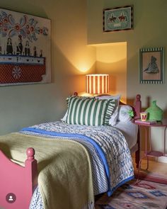 a bedroom with a bed, nightstand and pictures on the wall