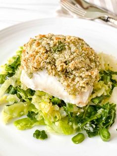 a white plate topped with fish covered in broccoli and parmesan cheese