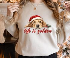 a woman wearing a christmas sweater with a golden retriever on it's chest