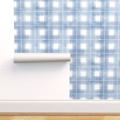 a wall mounted toilet paper dispenser in front of a blue checkered wall