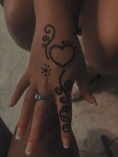 a woman's hand with a tattoo on it and a heart in the middle