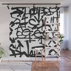 an abstract black and white painting on a wall with ladders in the foreground