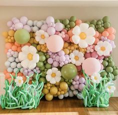 balloons and flowers are arranged on the wall