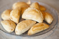 a glass plate filled with croissants on top of a table