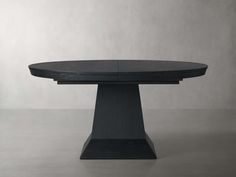 a round table with a black top on a grey background