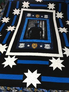 a black and blue quilt with white stars on the bottom, along with an image of a man