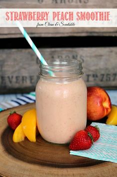 a smoothie in a mason jar with strawberries and peaches on the side