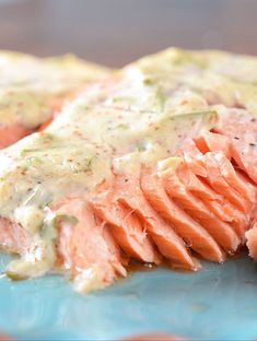 a piece of salmon covered in sauce on a blue plate