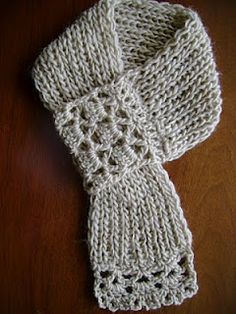 a white knitted scarf sitting on top of a wooden table