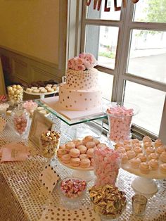 a table topped with lots of desserts next to a window