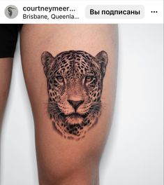 a close up of a person's leg with a tattoo on it that has a leopard head