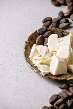 a spoon full of food sitting on top of a table next to beans and coffee beans