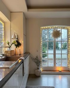 a kitchen with lights on the windows and a sink in front of an open door