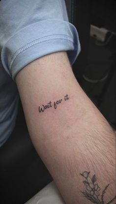 a person with a tattoo on their arm that says wait for it