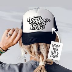 the back of a woman's head wearing a vintage trucker hat