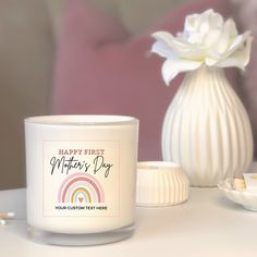 a white candle sitting on top of a table next to a vase filled with flowers