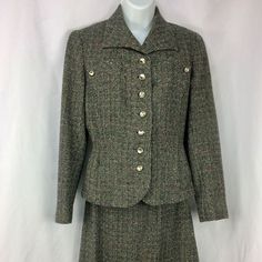 "A lovely lined women's suit by Fairbrooke--vintage 1940s or 1950s. Black and gray/white wool tweed with several secondary colors worked in, including teal, green, red, and orange. Interesting detailing on the chest, with smaller metal buttons that match the 7 buttons down the front. Spread-type collar; end of the jacket in front is curved, and the sleeves each have a small vent; 2 small pockets on either side. Jacket lining is sewn in all around; skirt lining is dark gray with pinked hem. There is no size tag, but I'm guessing this suit to be a small--make sure to see the measurements below! There is some staining and careful seam repair on the underarms--see last photo, Jacket measurements-- Underarm seam to underarm seam across back: about 18\" Waist: about 15.5\" Sleeve, from middle of Jacket Lining, Secondary Colors, Skirt Lining, Womens Suits, Red And Orange, Wool Suit, Saint Paul, Black And Gray, Metal Buttons