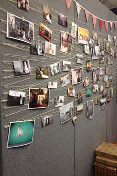 a bulletin board with pictures hanging from it's sides and clothes pins attached to the wall