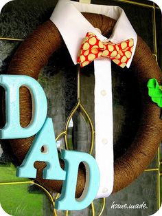 a father's day wreath with a bow tie on it and the word dad spelled out