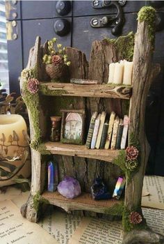 an old book shelf with moss growing on it and some candles in the corner next to it