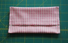 a pink and white checkered cloth sitting on top of a cutting board next to a ruler