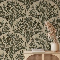 a vase with some plants in it on a table next to a wallpaper pattern