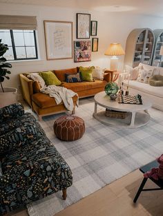 a living room with couches, chairs and tables in it's center area