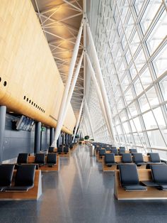 an airport terminal with lots of seats and tables lined up against the wall next to each other