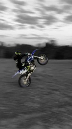 a person on a dirt bike doing a trick in the air over an open field