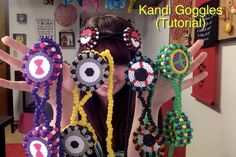 a woman is holding up several bracelets made out of beads