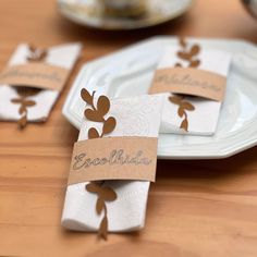 place cards are placed on napkins that have been wrapped in brown paper with leaves