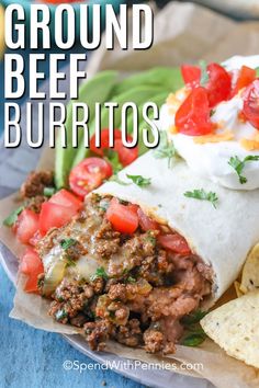 ground beef burritos with tomatoes, green beans and sour cream cheese on top