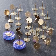 there are many different types of ear studs on the table, including one with blue and white dots