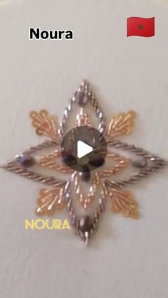 an image of a brooch with the words noura written in spanish on it