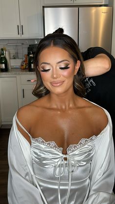 a woman getting her makeup done in the kitchen