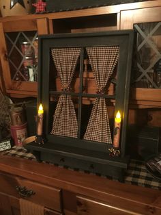 a black and white checkered table cloth with candles on it in front of a wooden hutch