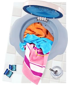 a blue toilet with colorful towels on it