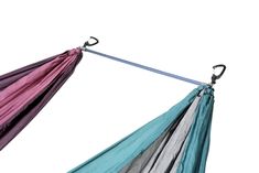 a multicolored hammock hanging upside down on a metal pole with two handles