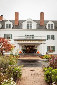 a large white building with lots of flowers in front of it