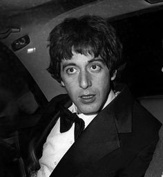 black and white photo of two men in tuxedos sitting next to each other