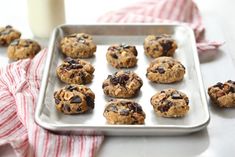 chocolate chip cookies on a baking sheet with a glass of milk