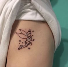 a small fairy tattoo on the side of a woman's thigh