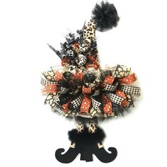 a black and orange halloween wreath on top of a stand with a giraffe