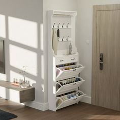 a white shoe rack in the corner of a room with a door open to show shoes and other items